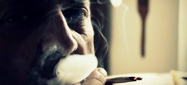 Un hombre fumando un porro.