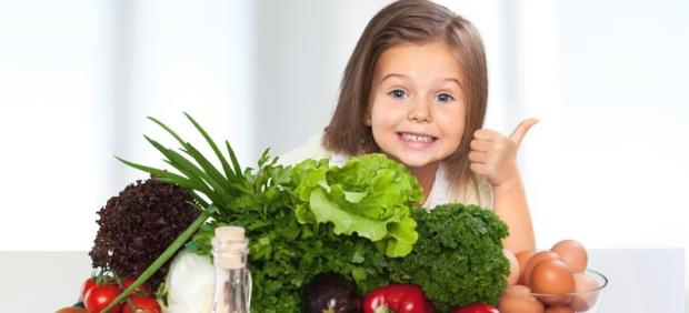 Dieta sana en niños. Niña comiendo verduras y hortalizas