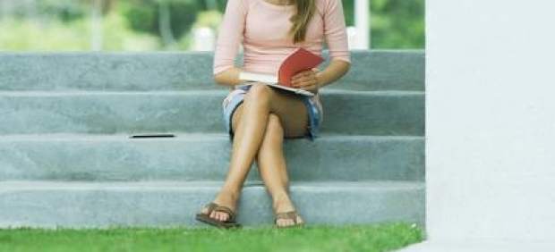 Una joven, sentada con las piernas cruzadas