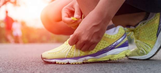 Un corredor atándose los cordones.