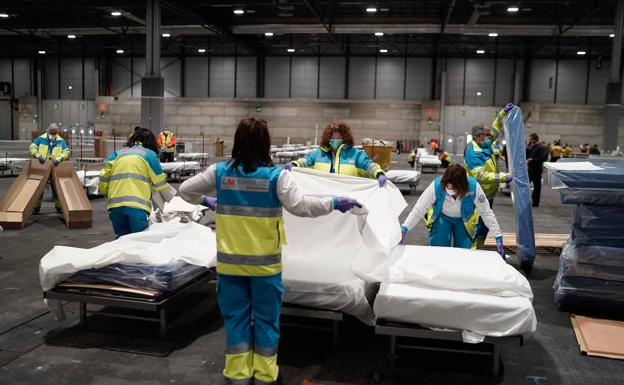 Personal de Emergencias montan las camas en la Feria de Madrid.